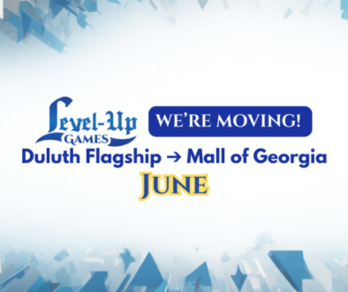 A promotional graphic with a white and light blue abstract geometric background. In the center, the Level Up Games logo appears next to a blue rounded button containing the text "WE’RE MOVING!" Below this, bold blue text reads "Duluth Flagship → Mall of Georgia." At the bottom, the word "JUNE" is written in a stylized yellow font with a blue outline, indicating the move date.